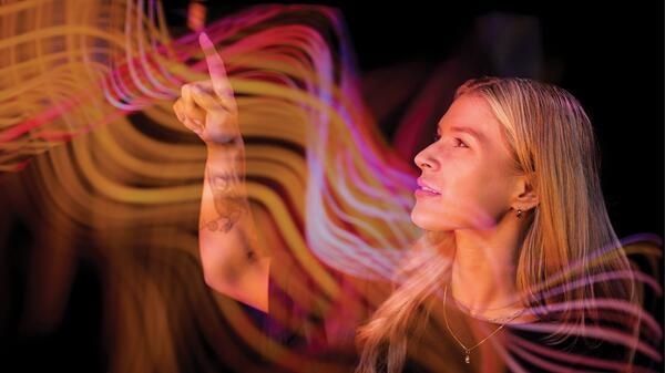 Photo illustration of woman interacting with waves in the air