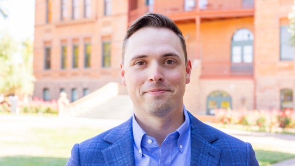 Photo of Andrew Napier wearing a blue suit outside 