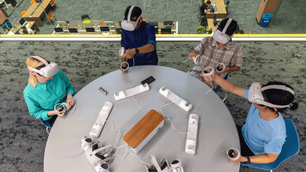 Several students wear virtual-reality headsets at a table