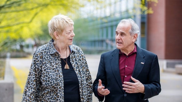 Lu Baird and ASU Biodesign Institute Executive Director Joshua LaBaer walk and talk outside of the Biodesign Institute building on the ASU Tempe campus.